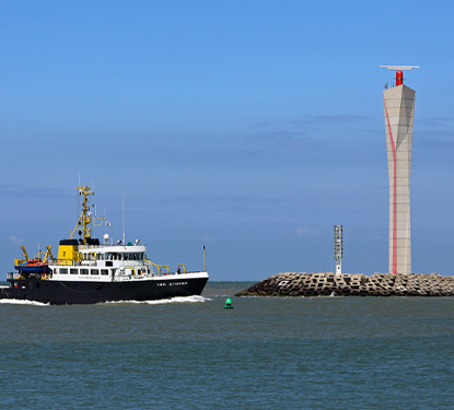 Belgian research and survey vessel Ter Streep entering the harbour of Ostend (Belgium); right: radar tower of the Schelderadarketen (Vessel Traffic Service) Photo by: Marc Ryckaert